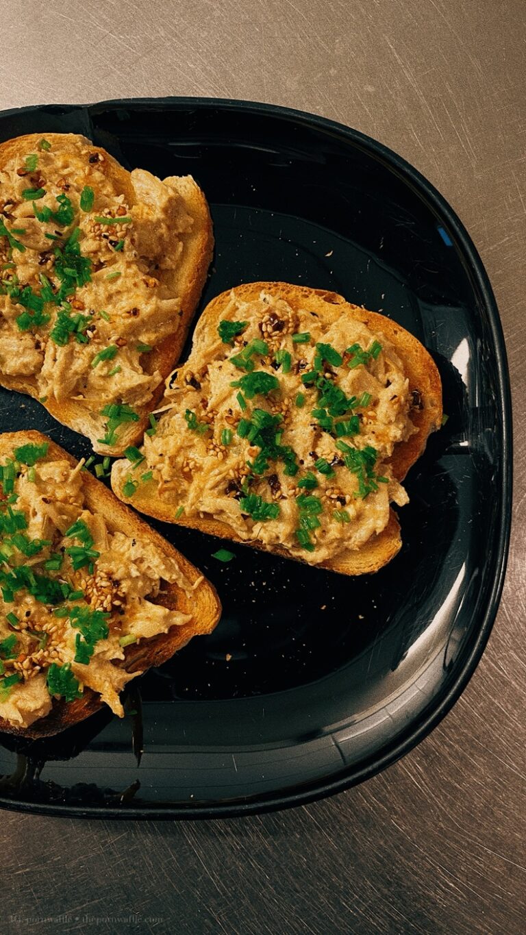 Shredded chicken mixed with cream and blue cheese on toast, topped with garlic chili oil with toasted sesame seeds and chives.